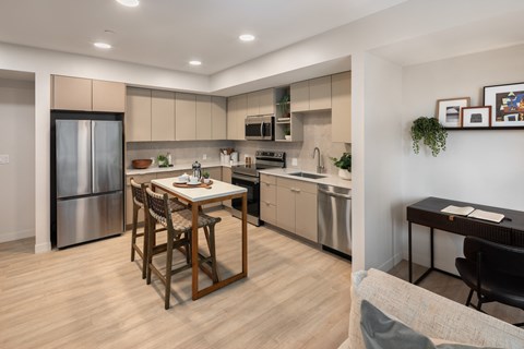 A modern kitchen with a dining table and chairs.
