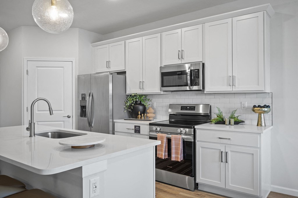 a kitchen with white cabinets and stainless steel appliances