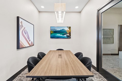 a conference room with a wooden table and black chairs