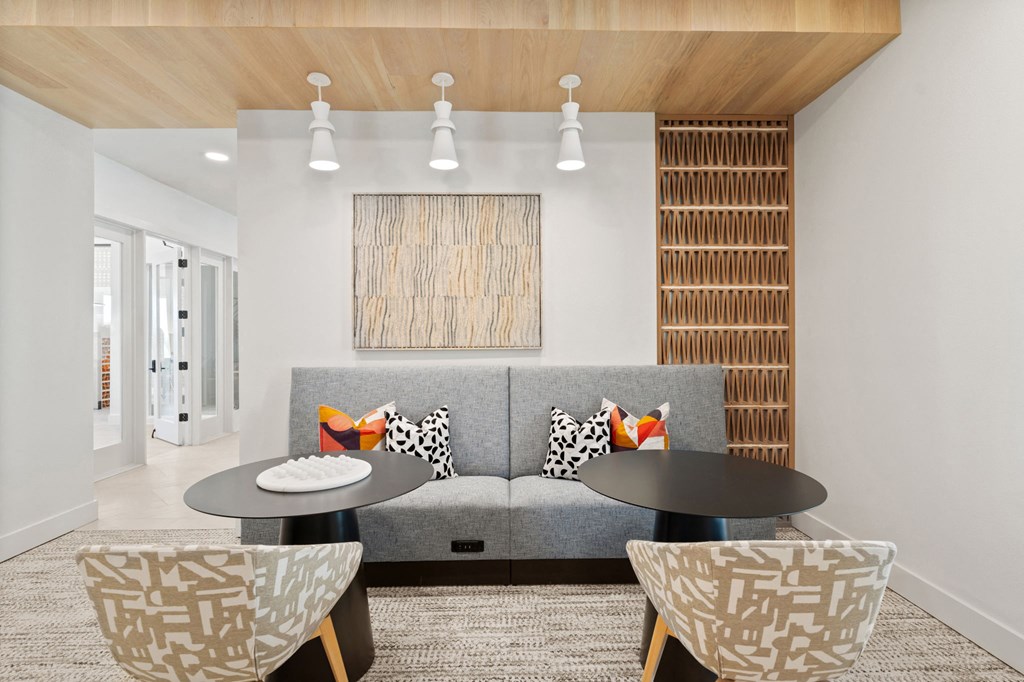 a room with a gray couch and two tables