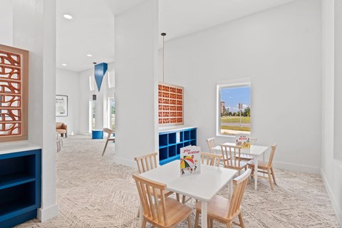 Children’s activity room featuring dedicated play tables, built-in storage, and space for creative learning.