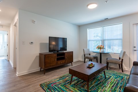 A living room with a wooden coffee table and a television on a cabinet.