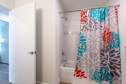 Bathroom featuring a tub and shower combination with a clean white surround and curtain.