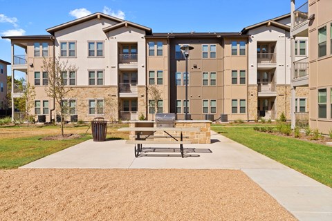 an outdoor patio with a picnic table in front of an apartment building