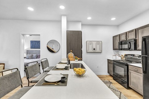 A modern kitchen with a dining table set for two.