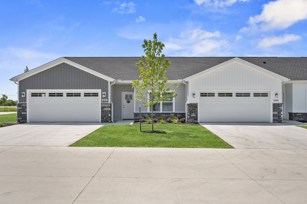 a house with two garage doors and a lawn in front of it