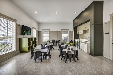 Activity Room with a table and chairs and a kitchen in the background