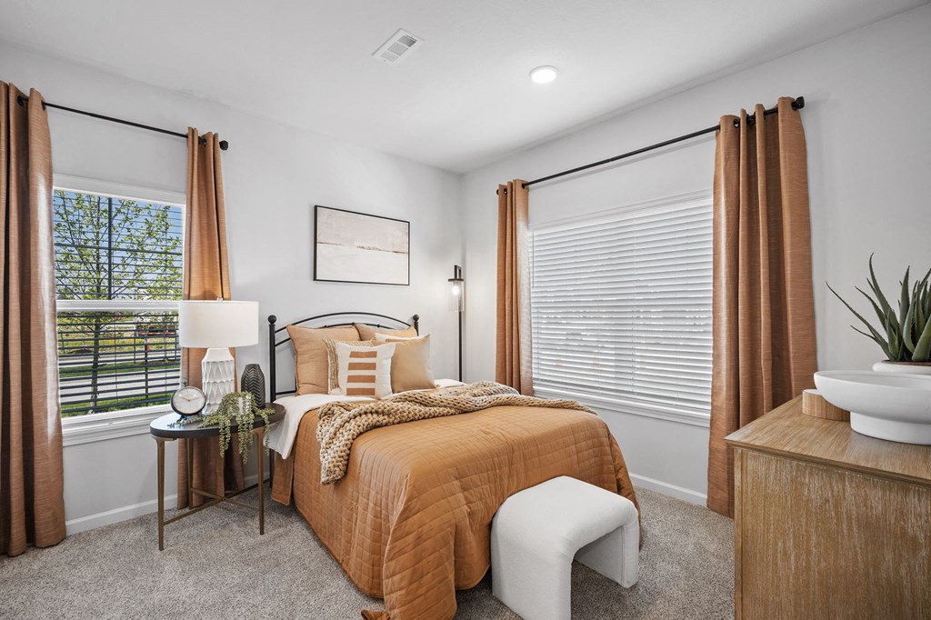 a bedroom with a bed and two windows