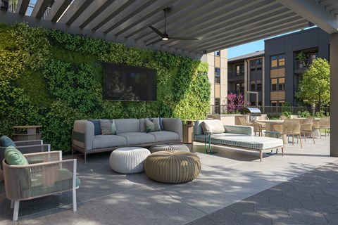 A patio with a green wall and furniture.