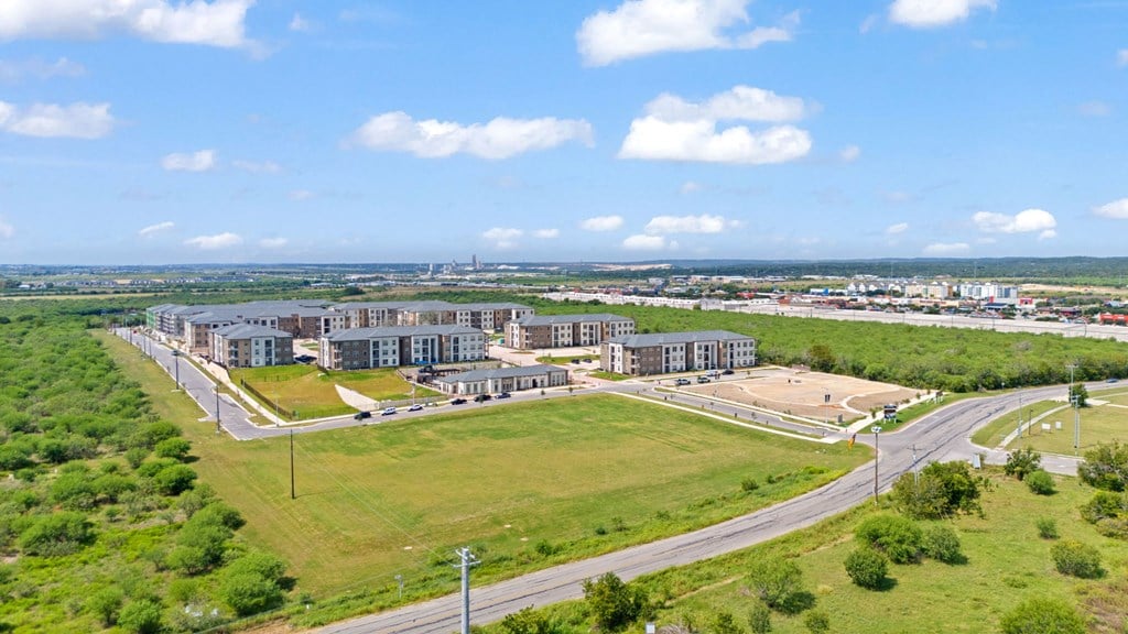 an aerial view of a city with buildings and a green field