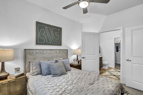 Bright bedroom featuring a comfortable upholstered bed, modern furnishings, and a large window that fills the space with natural light.