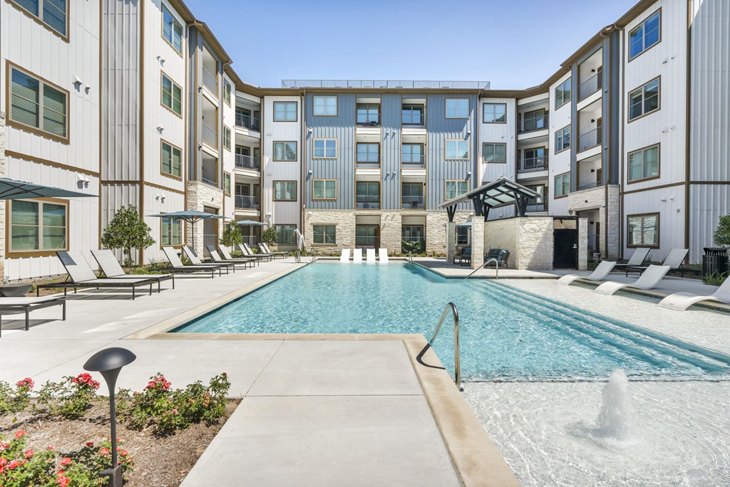 an outdoor swimming pool with an apartment building in the background