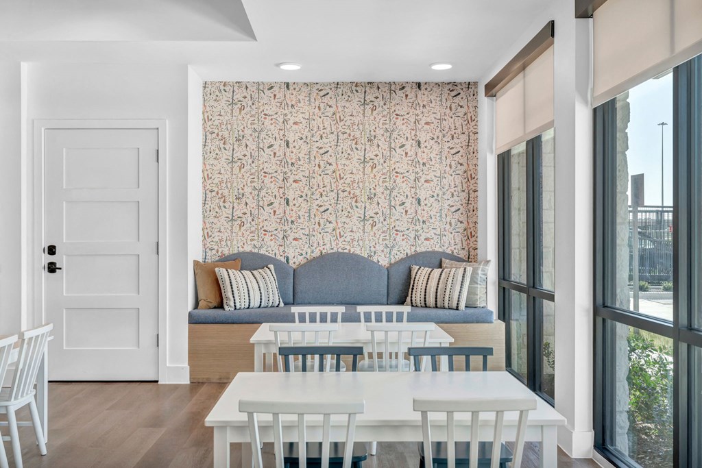 a blue couch and a white table and chairs