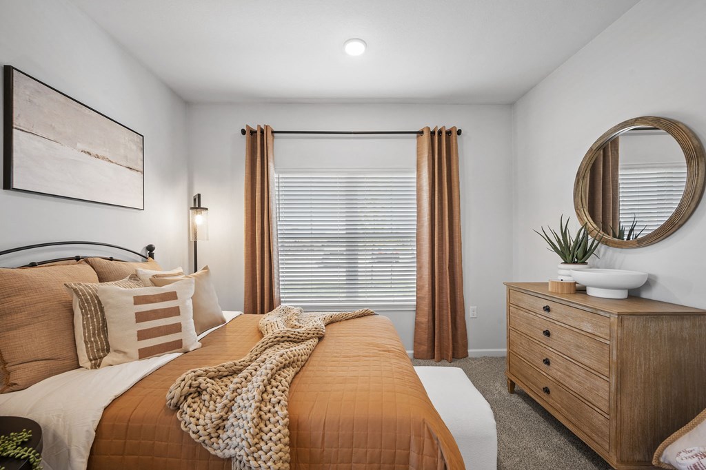 a bedroom with a bed and a dresser and a window
