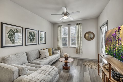 A living room with a grey sofa and a wooden coffee table.
