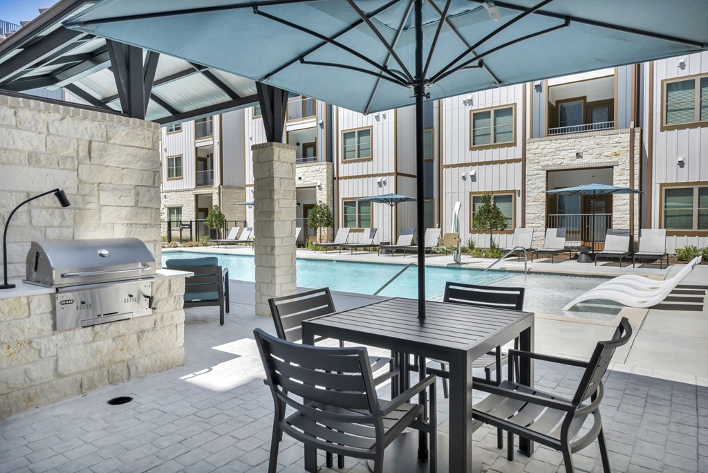 a patio with a table and chairs and a swimming pool