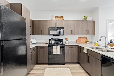 a modern kitchen with black appliances and wooden cabinets