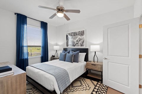 Bright bedroom featuring a ceiling fan and contemporary design elements.