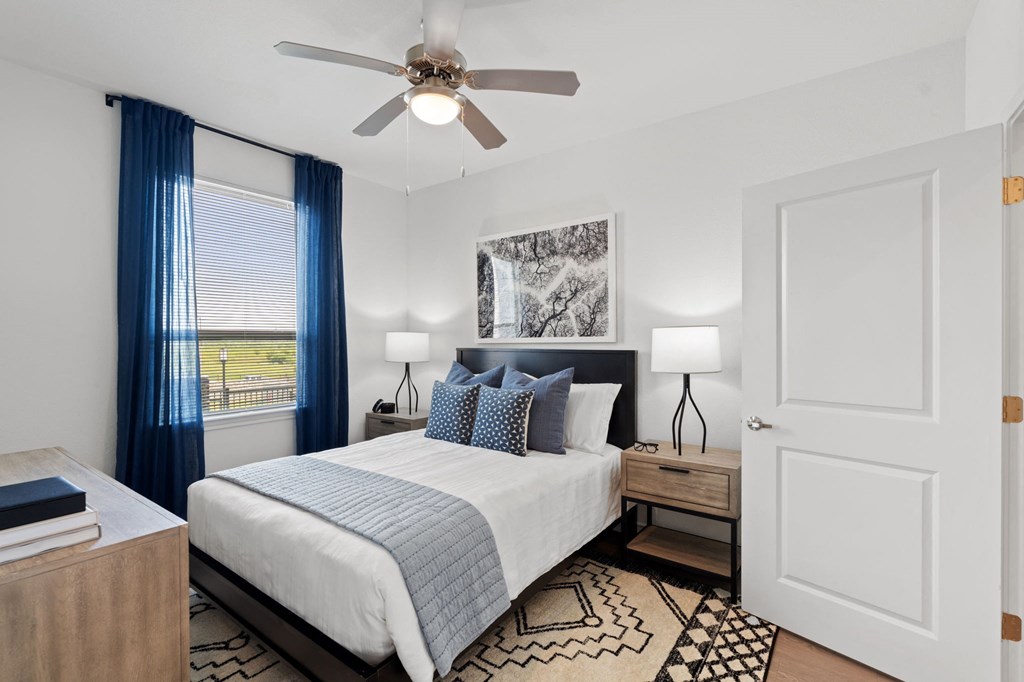 a bedroom with a bed and a ceiling fan