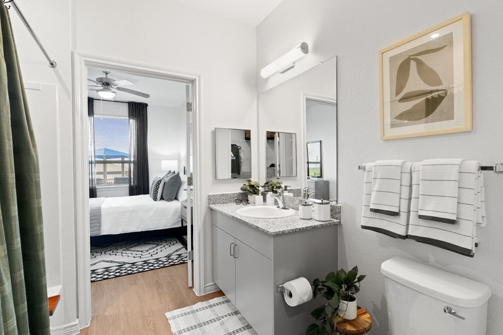 a bathroom with a large mirror and a toilet and a sink