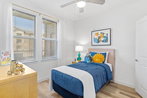 a bedroom with a bed and two windows