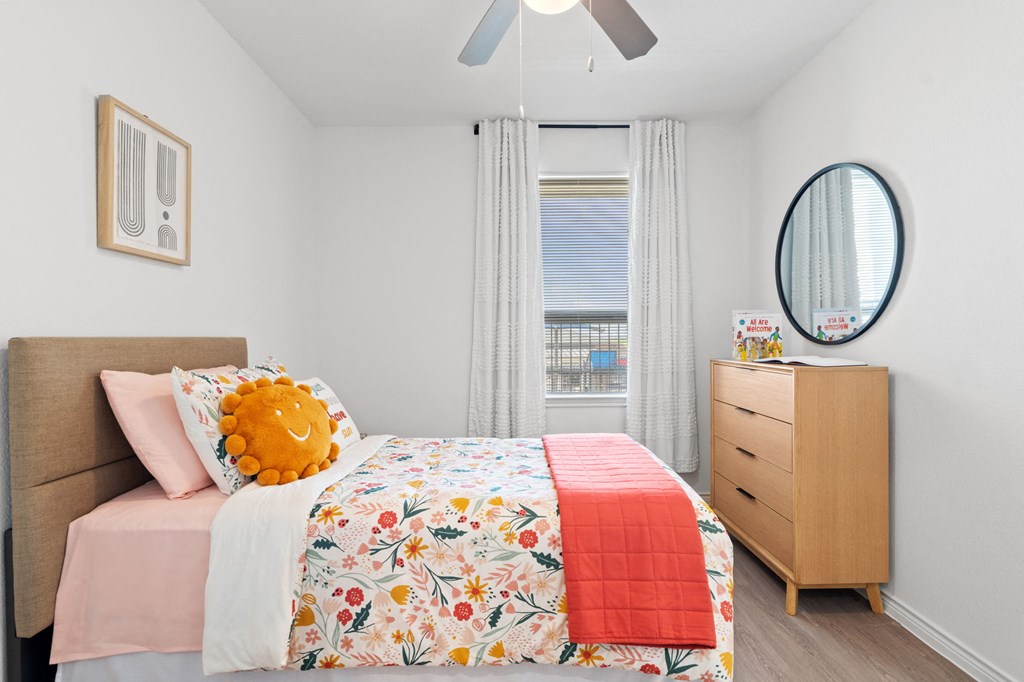 a bedroom with a bed and a dresser and a window