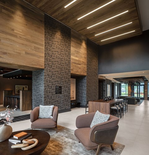 A modern living room with a wooden ceiling and a stone pillar.