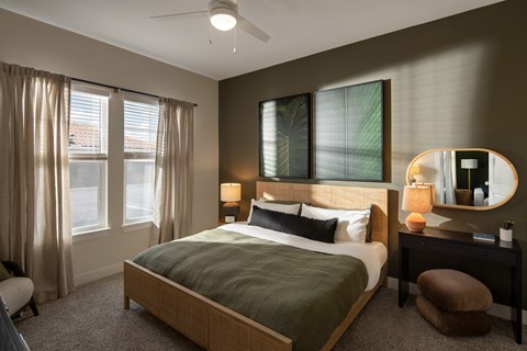 A bedroom with a large bed and a ceiling fan.