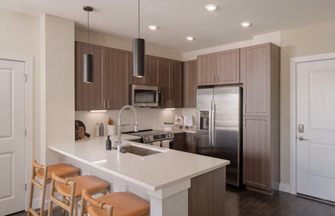 A kitchen with brown cabinets and white countertops.