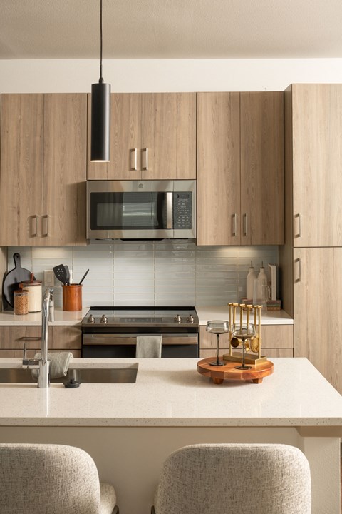 A modern kitchen with wooden cabinets and a white countertop.