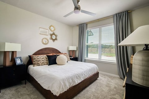 a bedroom with a large bed and a ceiling fan