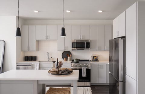A modern kitchen with white cabinets and a central island.