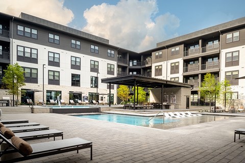 A large apartment complex with a pool in the courtyard.