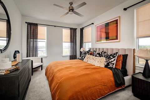 A bedroom with a bed in the center and a painting on the wall above it.
