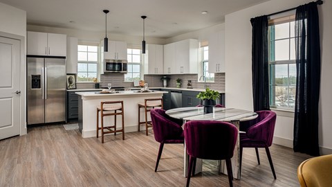 A modern kitchen with a dining table and chairs.