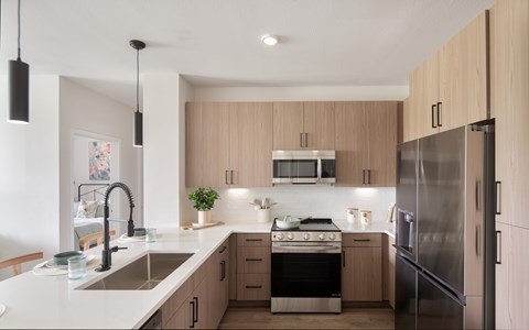 A modern kitchen with wooden cabinets and stainless steel appliances.