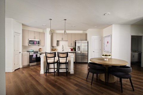A modern kitchen with a dining table and chairs.