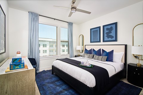 A bedroom with a large bed and a ceiling fan.