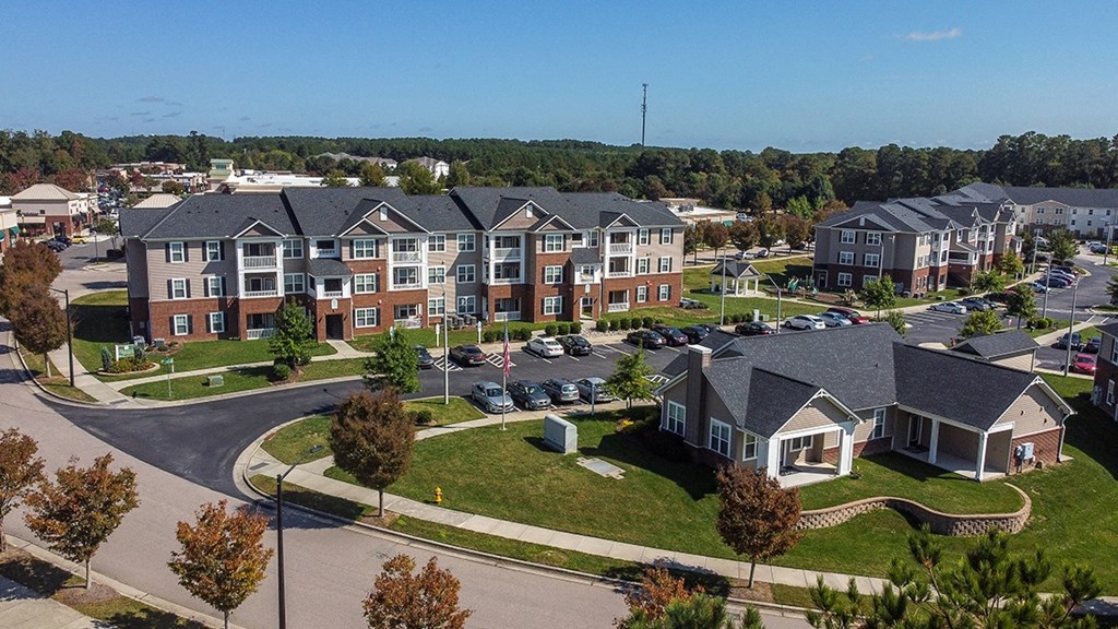 an aerial view of an apartment complex with cars parked in a parking lot