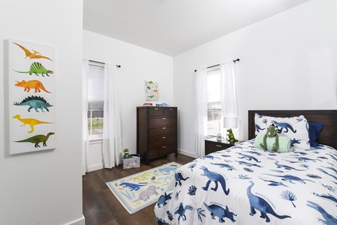Comfortable bedroom with a twin bed, decorative artwork, and a clean layout designed for a playful and functional space.