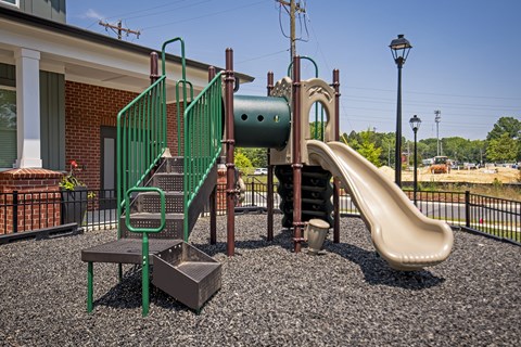 A playground with a green slide and a brown slide.