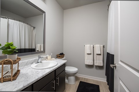 A bathroom with a white sink and a toilet.
