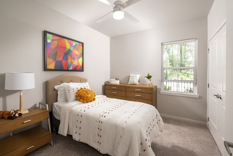 A bedroom with a large bed and a ceiling fan.