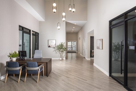 A modern office with a desk, chairs, and a computer.