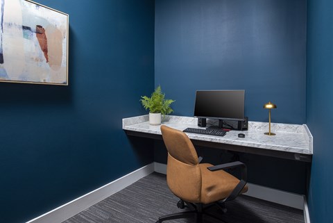 A brown chair is in front of a desk with a computer on it.
