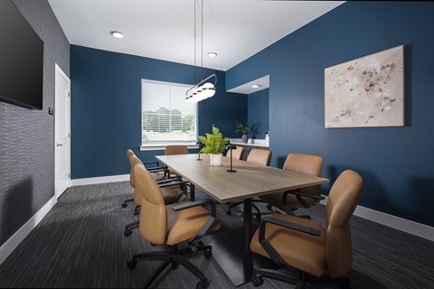 A conference room with a long table and chairs.