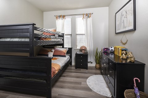 A bedroom with a bunk bed and a dresser.