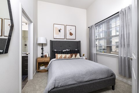 Spacious primary bedroom featuring comfortable furnishings, abundant natural light, and a relaxing atmosphere designed for everyday comfort.