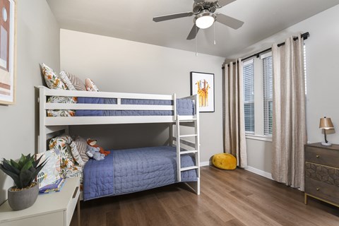 Secondary bedroom featuring a bunk bed setup, neutral finishes, and nearby windows.