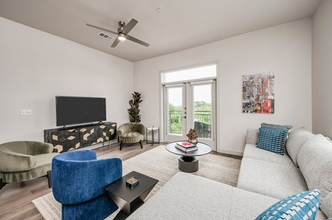 A living room with a blue chair and a white couch.